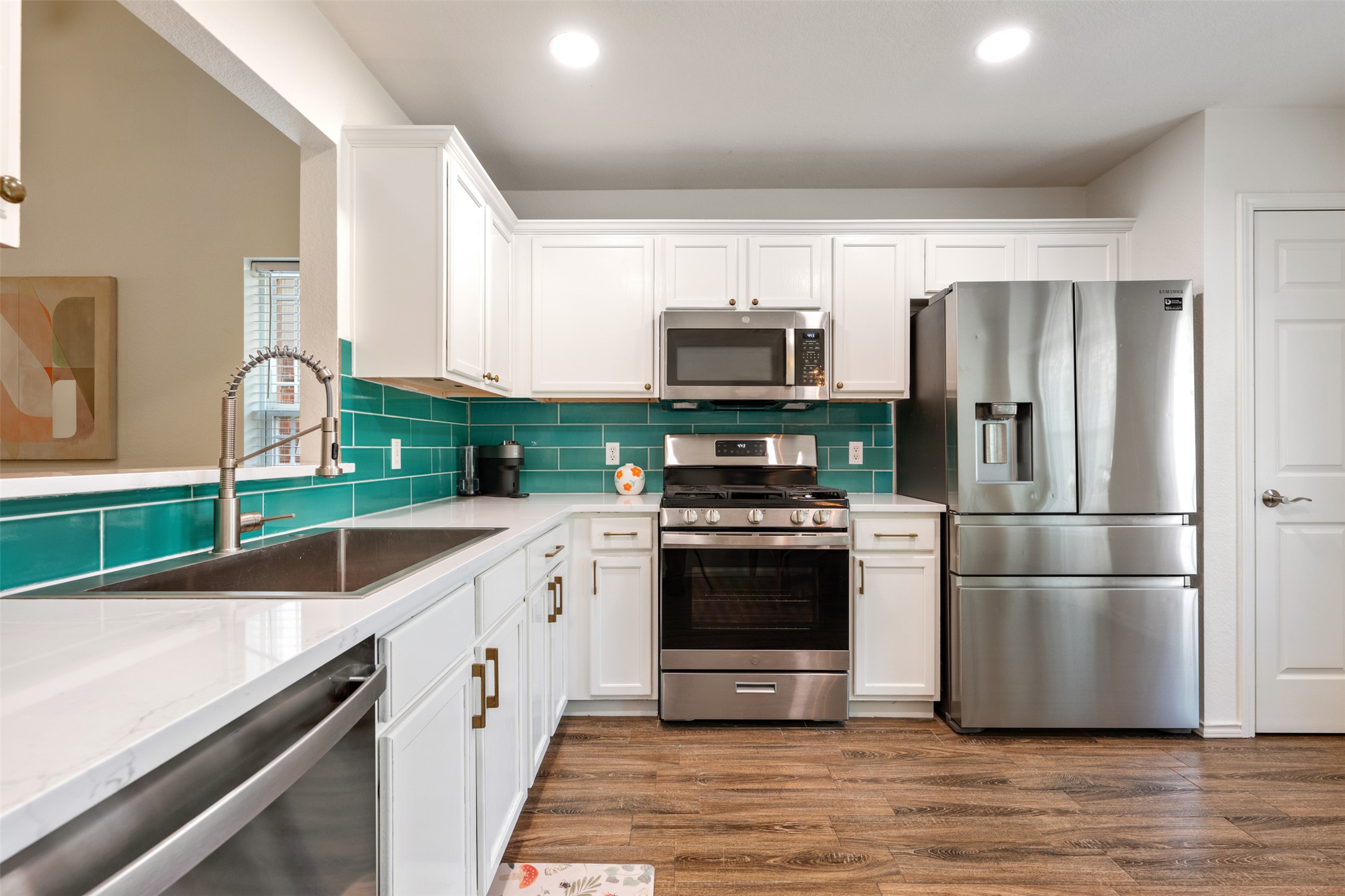 3116 Port Anne Way Leander, TX 78641 - Photo 8 of 24 Updated kitchen with quartz counters, tile backsplace, stainless appliances and white cabinets.