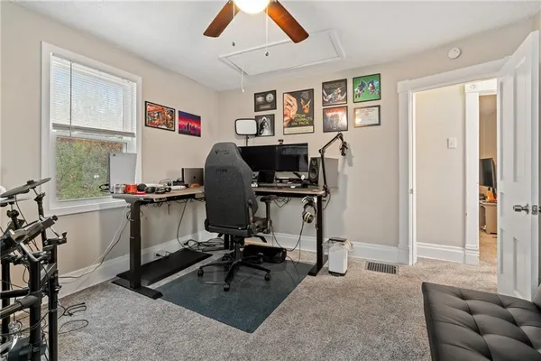 a view of a workspace with furniture and a window