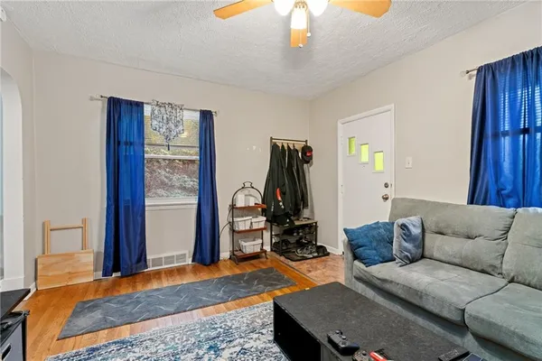 a living room with furniture a flat screen tv and a chandelier