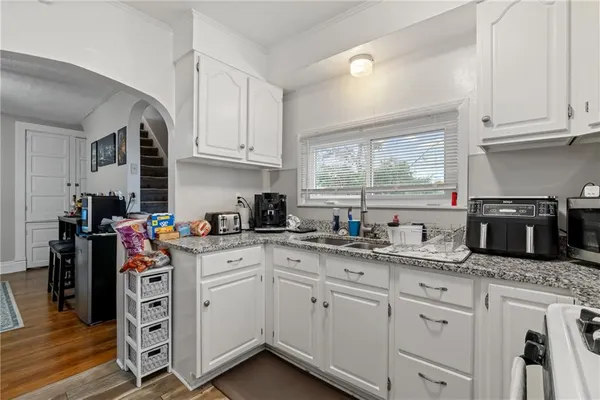 a kitchen with granite countertop white cabinets and white appliances