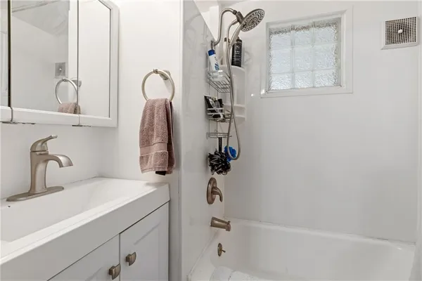 a bathroom with a shower sink and mirror