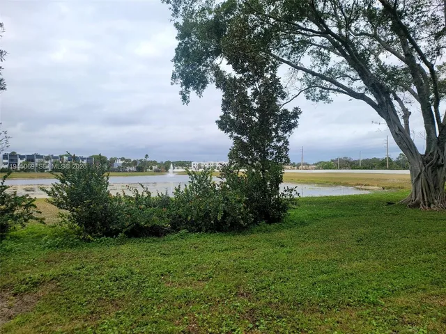 a view of yard with green space and trees around