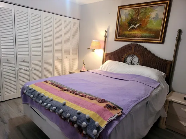 a bedroom with a bed and a painting on the wall