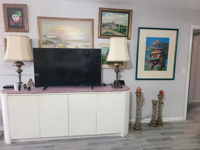 a living room with a flat screen tv and a lamp on table