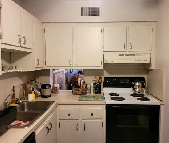 a kitchen with a stove and white cabinets