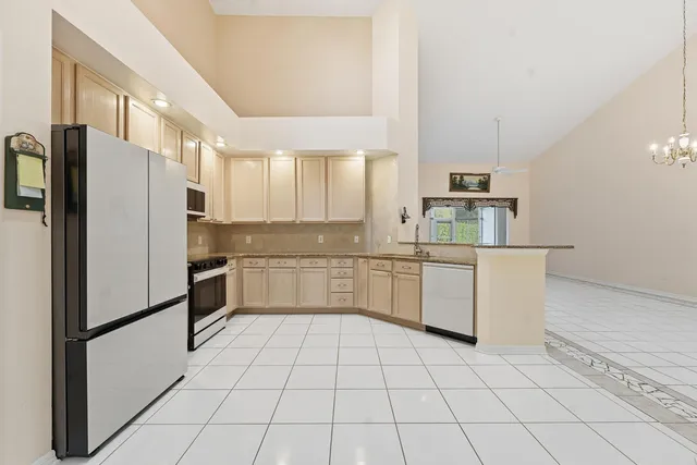 a kitchen with granite countertop a refrigerator and a stove top oven