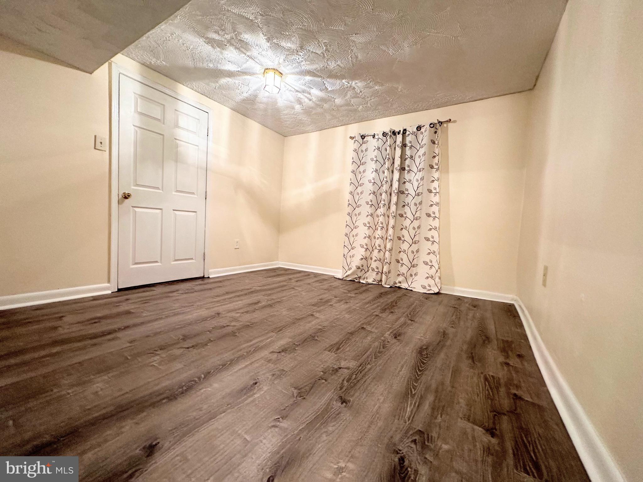 6802 Killarney Street Clinton, MD 20735 - Photo 15 of 19 a view of empty room with wooden floor and fan