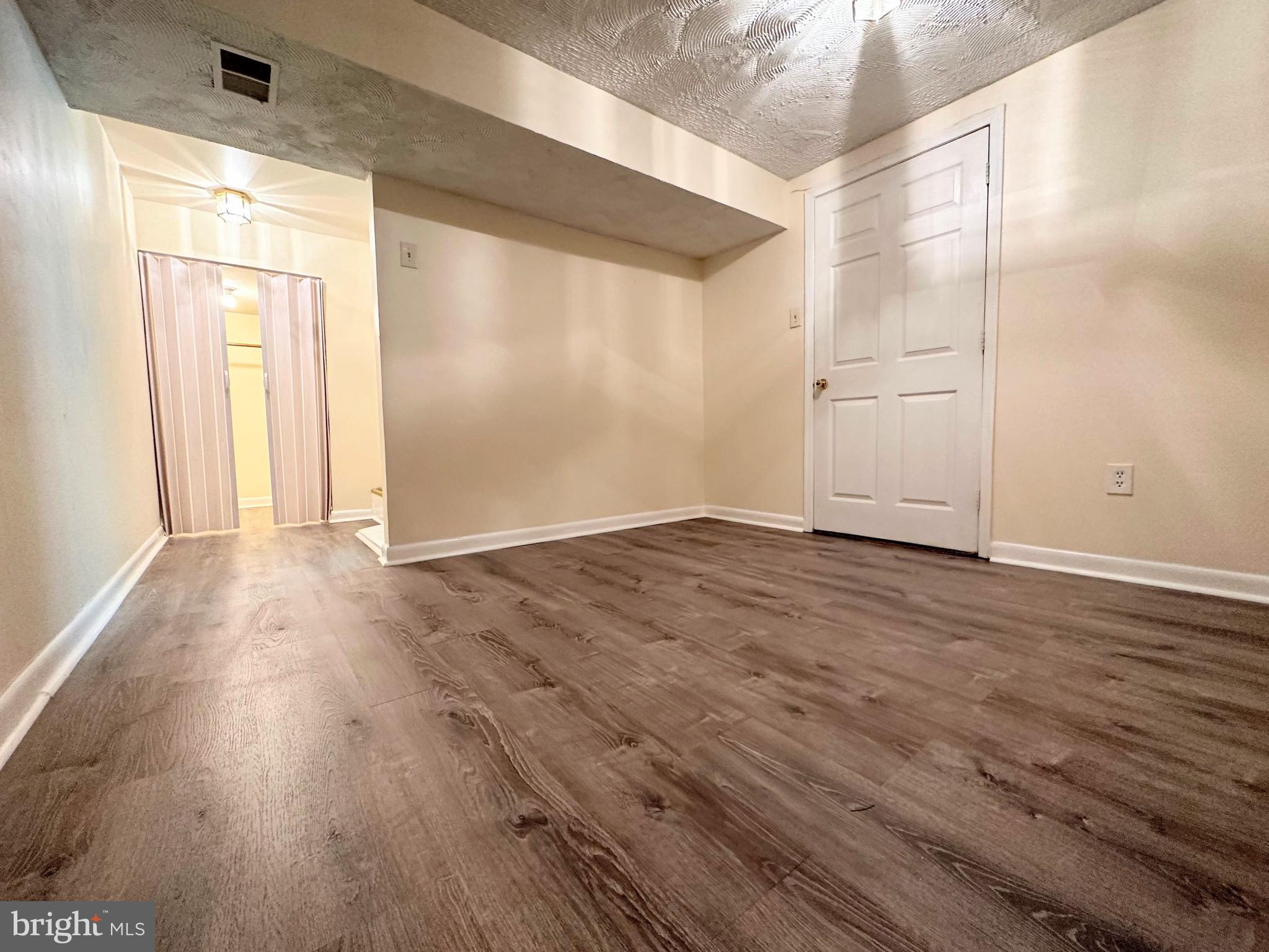 6802 Killarney Street Clinton, MD 20735 - Photo 16 of 19 an empty room with wooden floor and windows