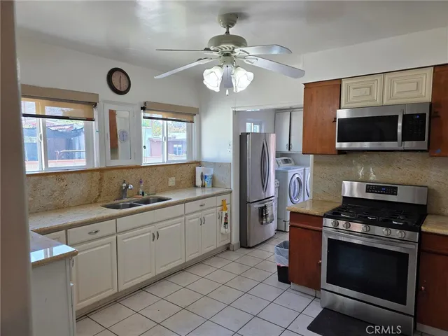 a kitchen with stainless steel appliances a stove microwave and a sink