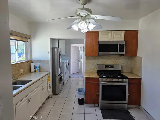 a kitchen with stainless steel appliances a stove sink microwave and cabinets