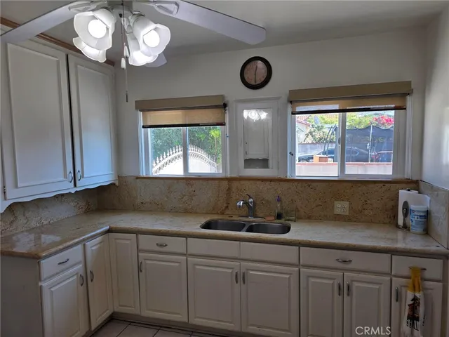 a kitchen with cabinets a window and stainless steel appliances
