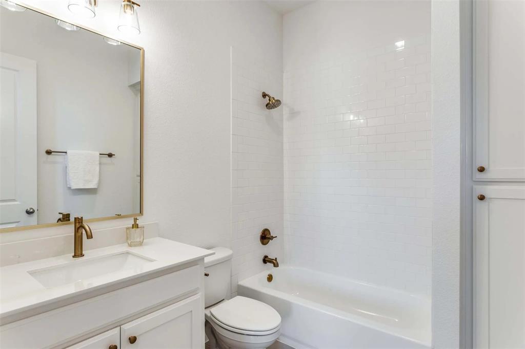 8965 Armstrong Court Benbrook, TX 76126 - Photo 19 of 24 a bathroom with a bathtub shower sink vanity mirror and toilet