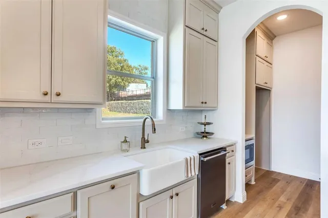 a kitchen that has a lot of cabinets and a wooden floor