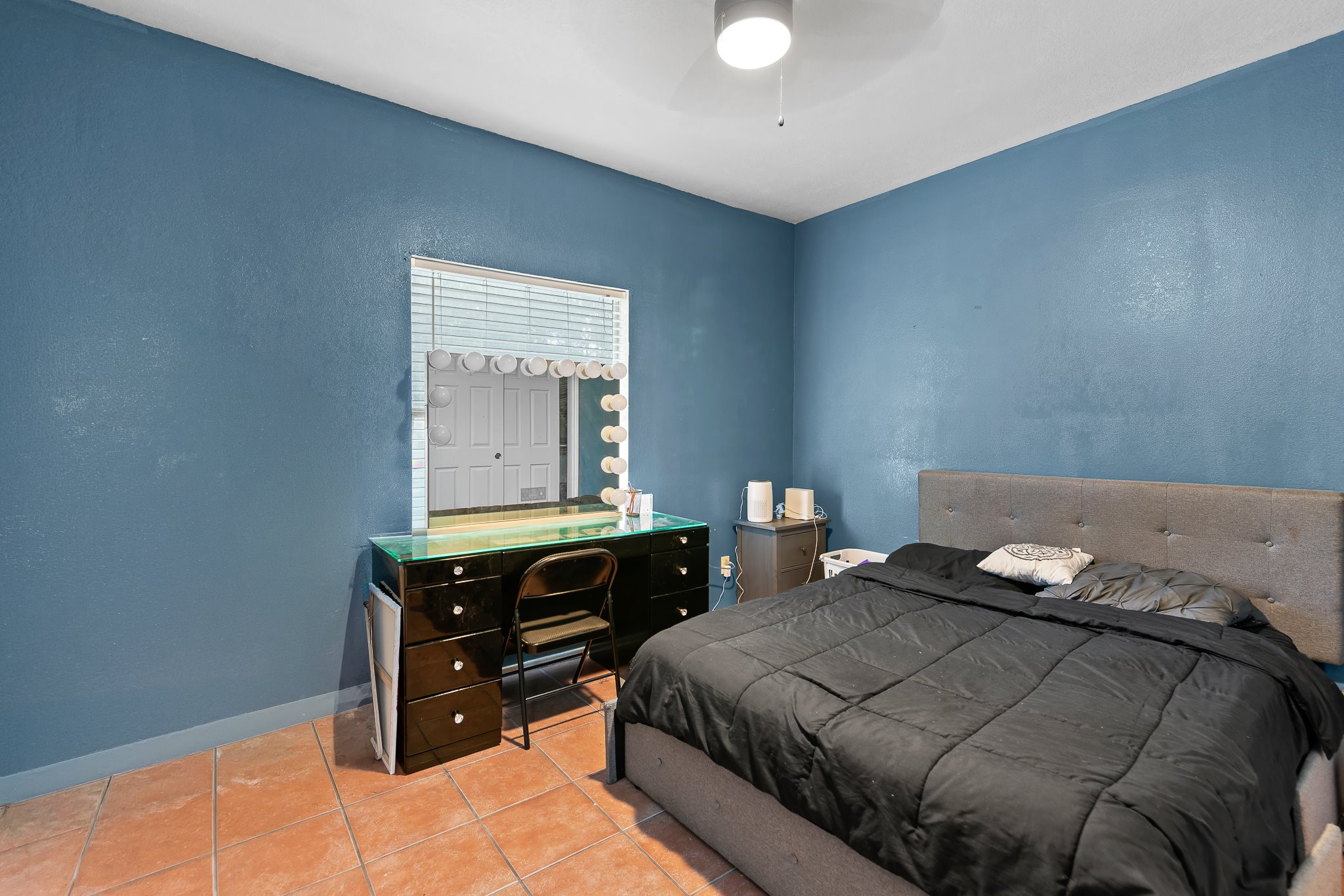 11737 Rydalwater Lane Austin, TX 78754 - Photo 13 of 40 Blue-painted interior room featuring terracotta-style floor tiles, a window with horizontal blinds, and a ceiling-mounted light fixture