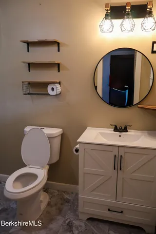 a bathroom with a toilet mirror and vanity