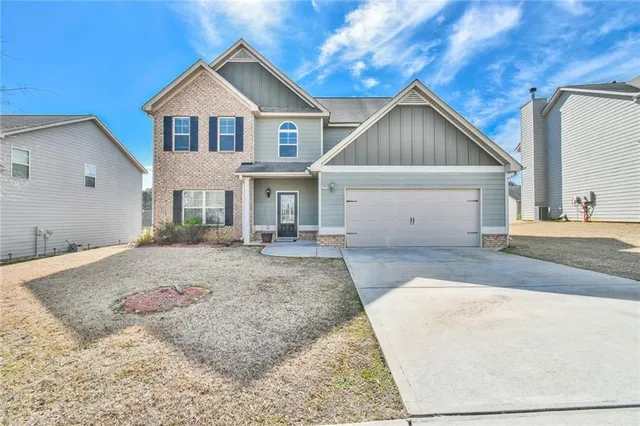 a view of a house with a yard and garage