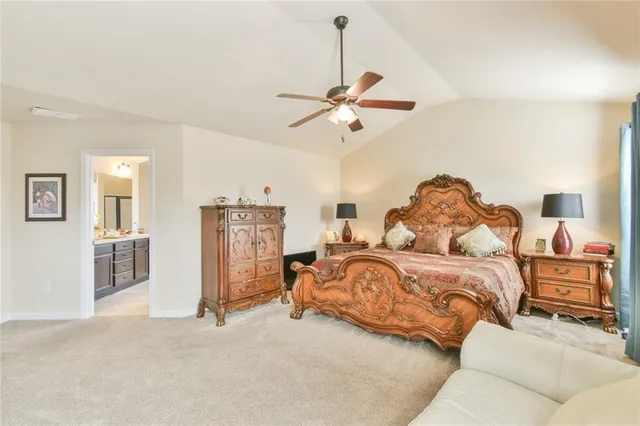 a spacious bedroom with a bed a ceiling fan and a dresser