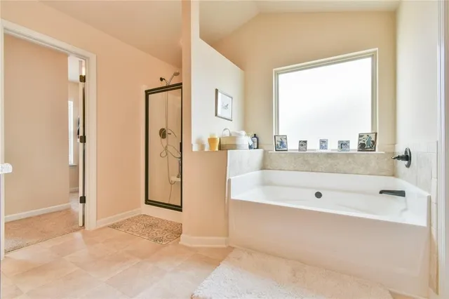 a spacious bathroom with a tub shower and a sink