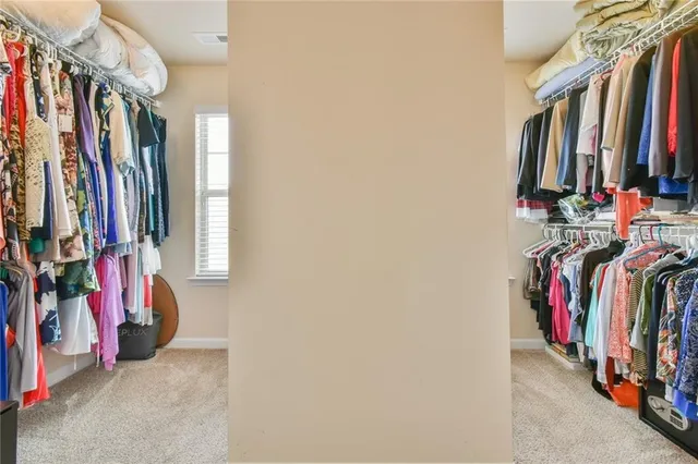 a view of walk in closet with clothes