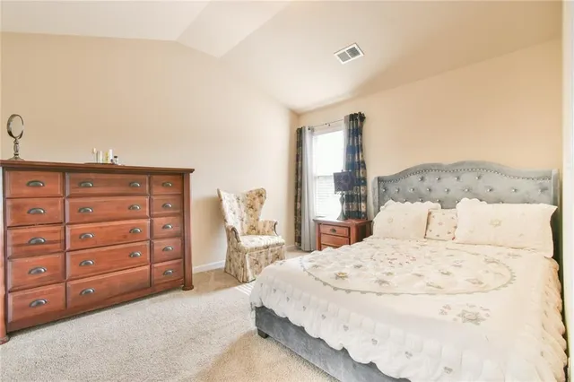 a bedroom with a large bed and a dresser