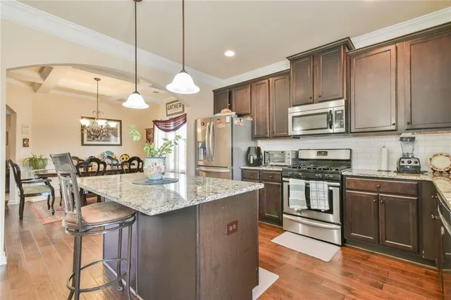 a kitchen with stainless steel appliances granite countertop a sink a stove and a refrigerator
