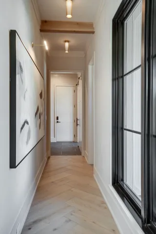 a view of a hallway with wooden floor and dining room with furniture