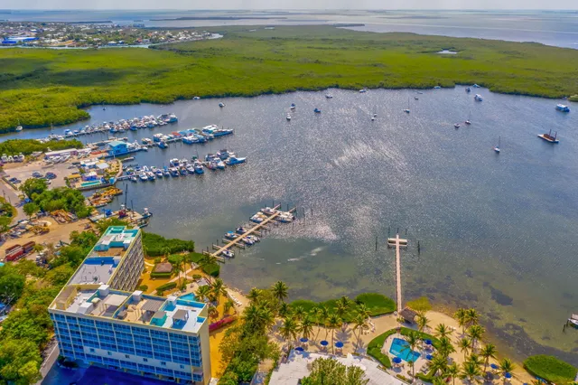 a view of a hallway with wooden floor and a bathroom