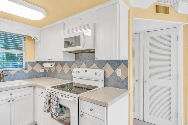 a kitchen with a refrigerator a stove a sink and a window