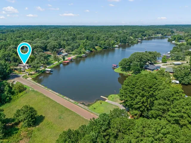 an aerial view of a house with a yard and lake view