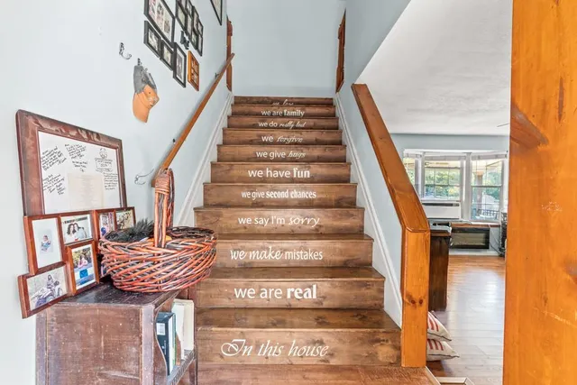 a view of a hallway with wooden floor and stairs