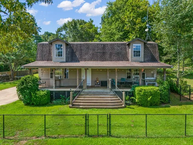 a view of a house with backyard and sitting area