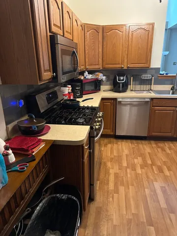 a kitchen with stainless steel appliances a stove a sink dishwasher and a microwave oven on the table