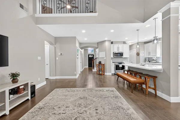 a living room with stainless steel appliances kitchen island granite countertop furniture wooden floor and a view of living room