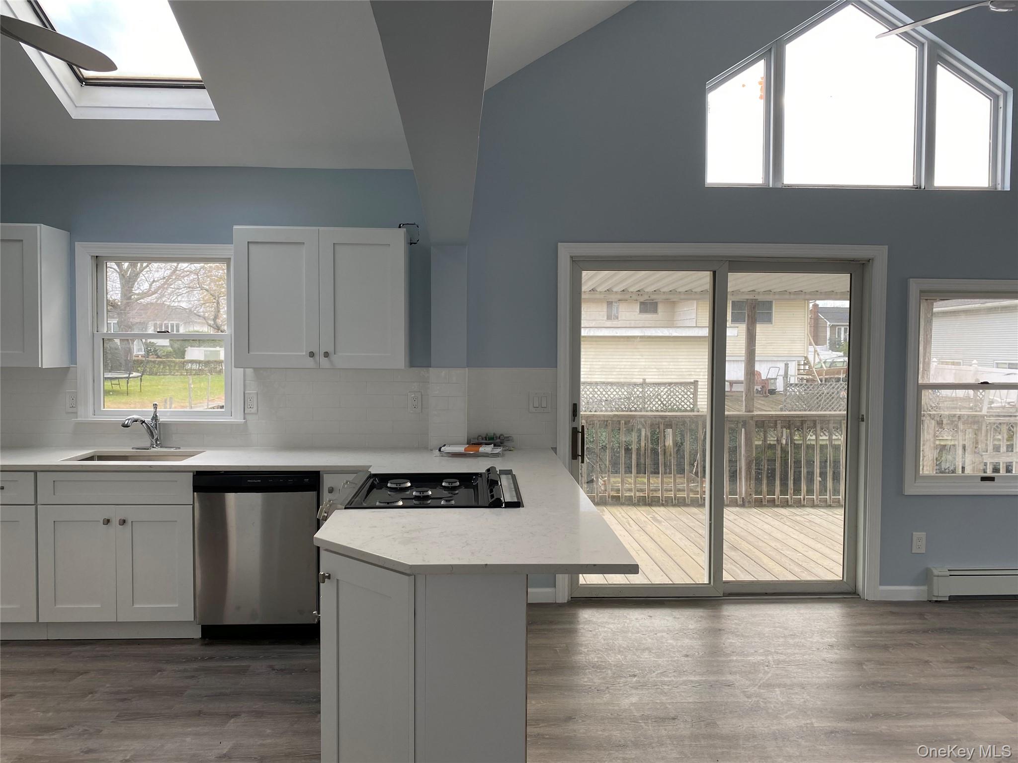 115 Barbara Road Bellmore, NY 11710 - Photo 3 of 13 Light Filled Open Kitchen and Living Room with Sliding Doors To Back Deck and Dock Space