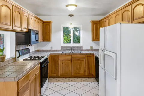 a kitchen with stainless steel appliances granite countertop a refrigerator stove and sink