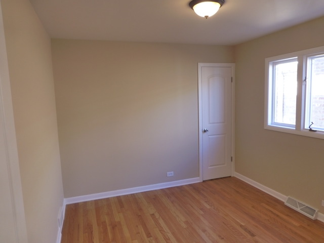 6840 West 64th Street Chicago, IL 60638 - Photo 19 of 19 a view of an empty room with wooden floor and a window