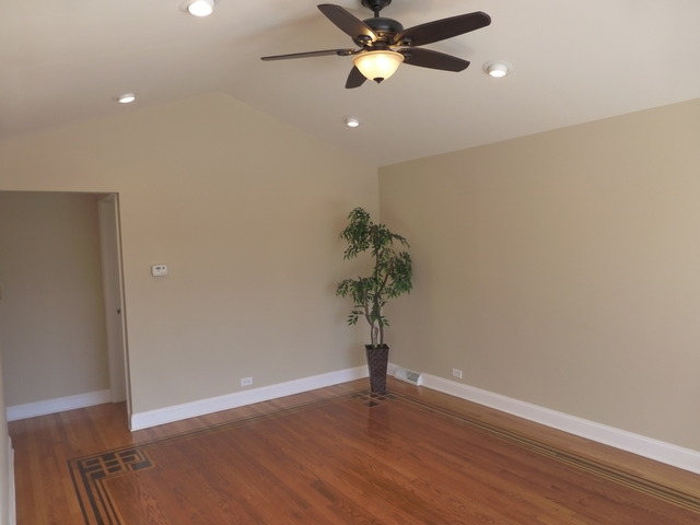 6840 West 64th Street Chicago, IL 60638 - Photo 3 of 19 a view of a room with wooden floor and a ceiling fan