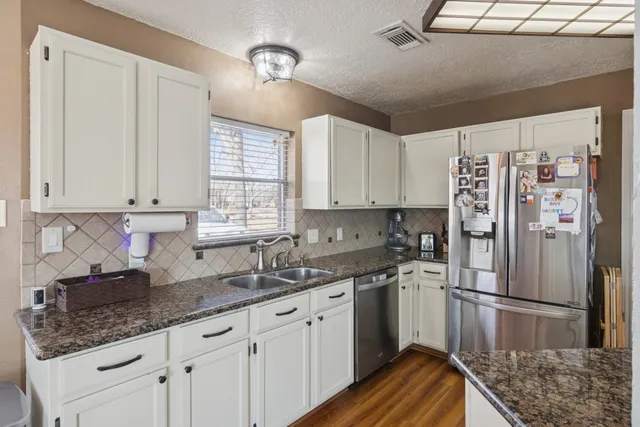 a living room with a bed bookshelf and a large window