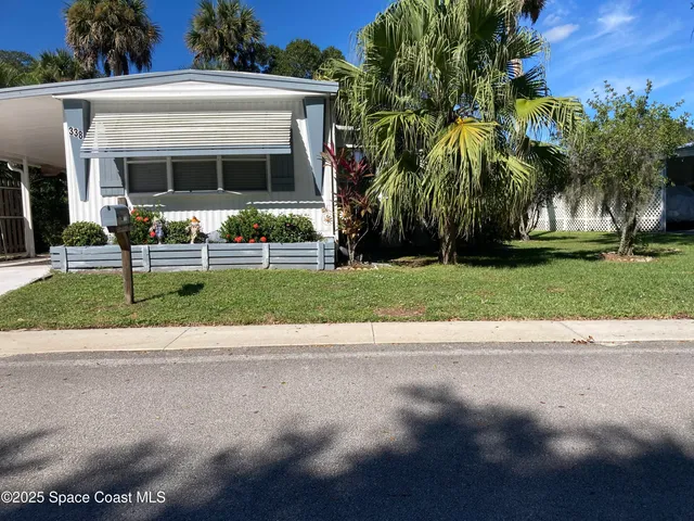 a view of a house with a yard and a street