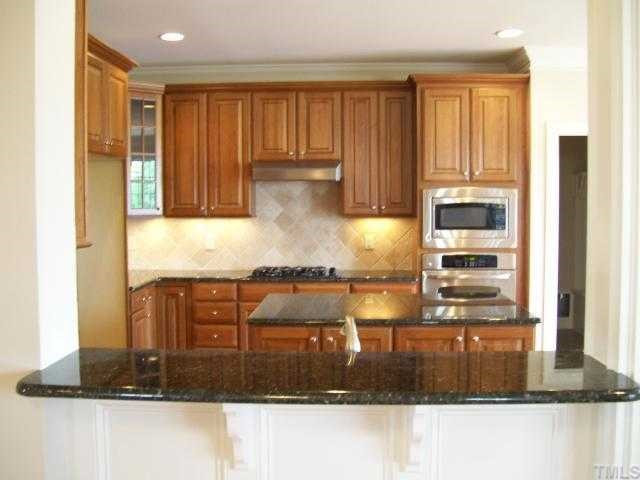534 Chapanoke Road Raleigh, NC 27603 - Photo 3 of 12 The kitchen is open to the family room and offers granite countertops, tile backsplash, stainless steel appliances, custom cabinets, gas cooktop, pantry, butler's pantry, and a breakfast nook. Kitchen
