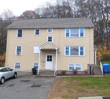 a front view of a house with a garden and plants