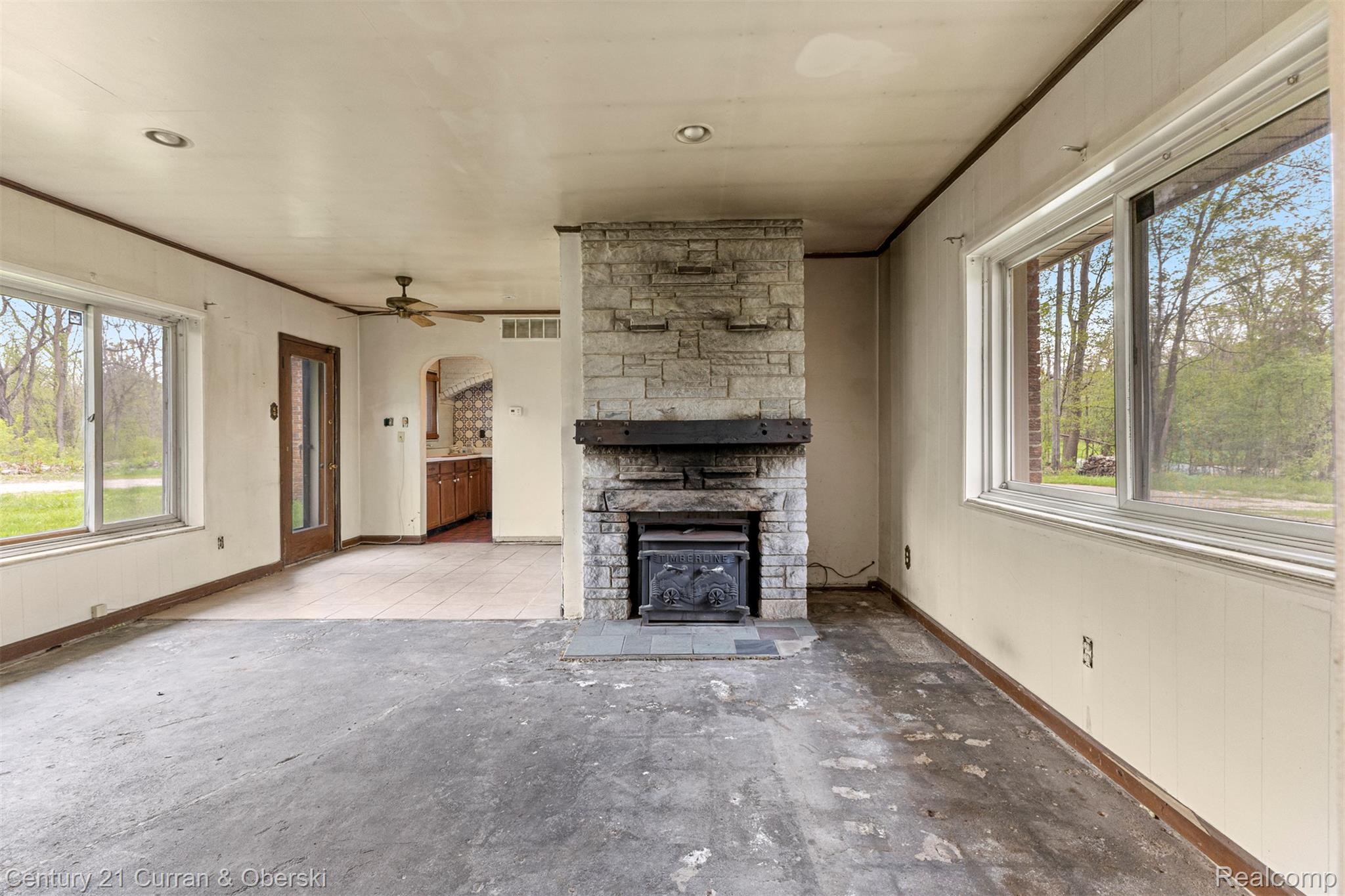 25205 Inkster Road Farmington, MI 48336 - Photo 8 of 46 Unfurnished living room featuring a fireplace, ornamental molding, and a ceiling fan