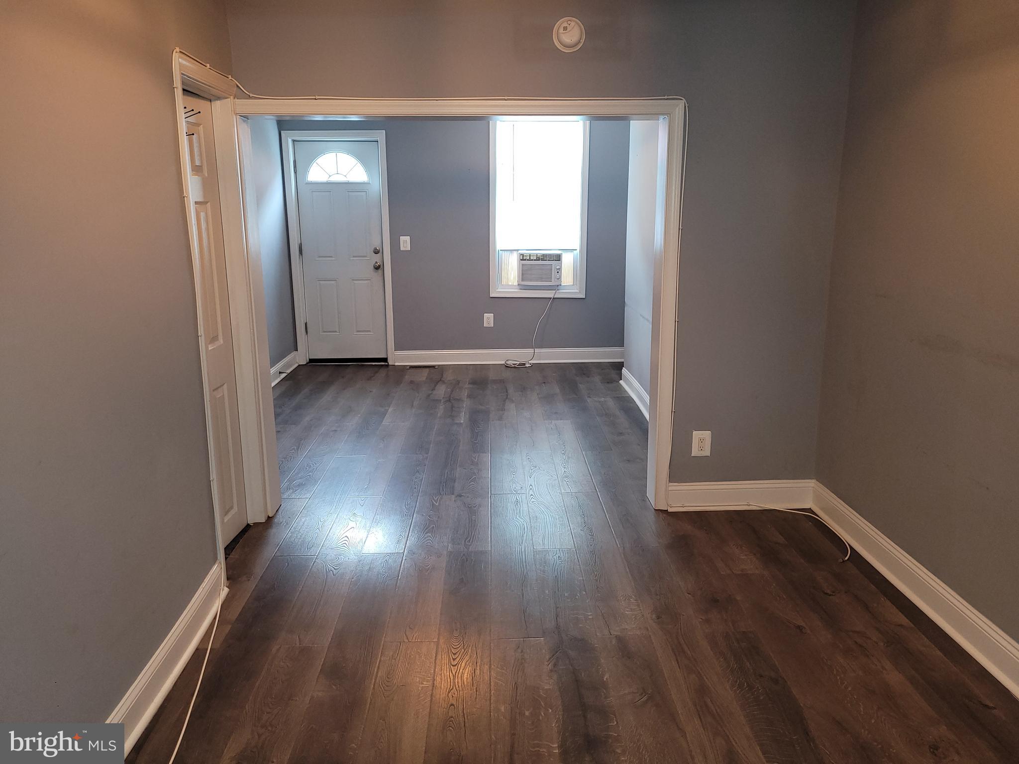 617 Archer Street Baltimore, MD 21230 - Photo 2 of 12 an empty room with wooden floor and windows