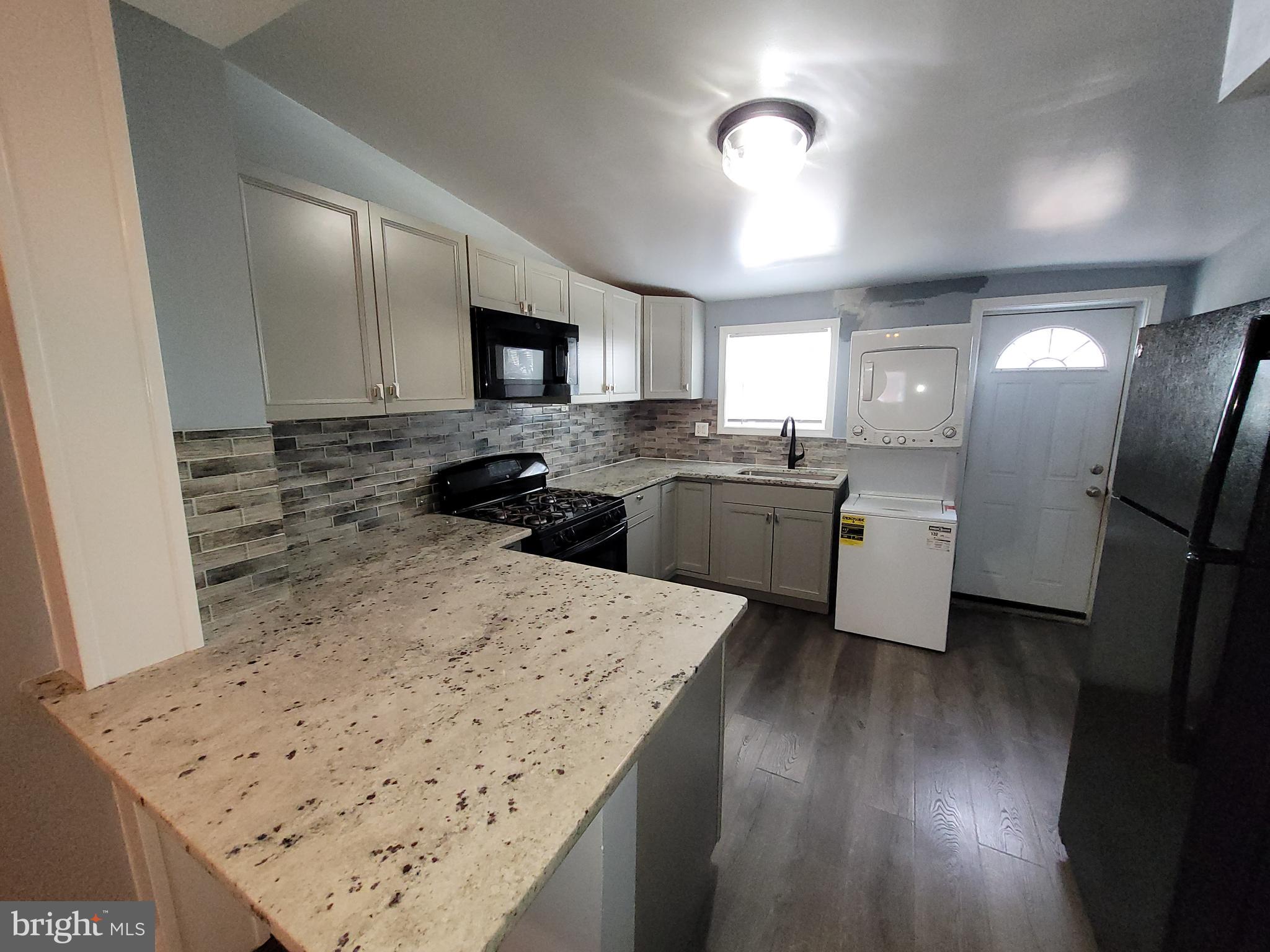 617 Archer Street Baltimore, MD 21230 - Photo 5 of 12 a kitchen with stainless steel appliances kitchen island granite countertop refrigerator sink and stove