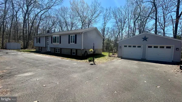 a view of a house with a large tree and a yard