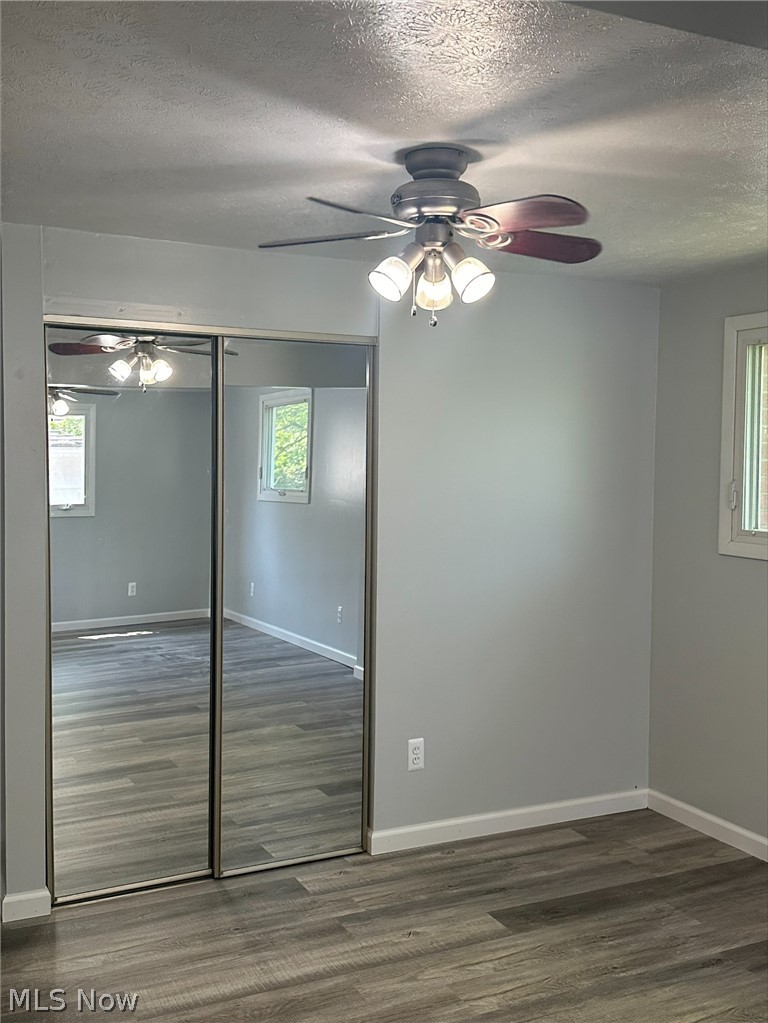 1001 Keefer Road Girard, OH 44420 - Photo 10 of 42 Master bedroom with hardwood / wood-style flooring, a textured ceiling, a closet, and ceiling fan