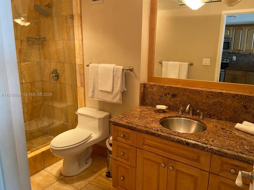 100 Lincoln Road, Unit 1631 Miami Beach, FL 33139 - Photo 12 of 30 a bathroom with a granite countertop toilet a sink and a mirror