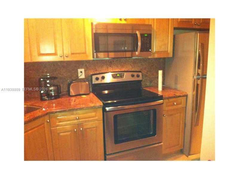 100 Lincoln Road, Unit 1631 Miami Beach, FL 33139 - Photo 10 of 30 a kitchen with a stove and a microwave