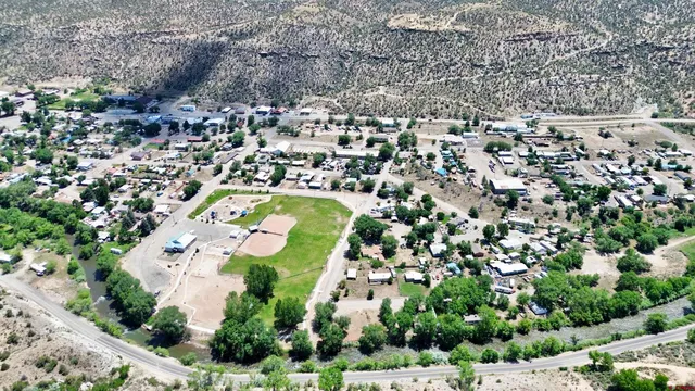 an aerial view of residential houses with outdoor space and trees all around