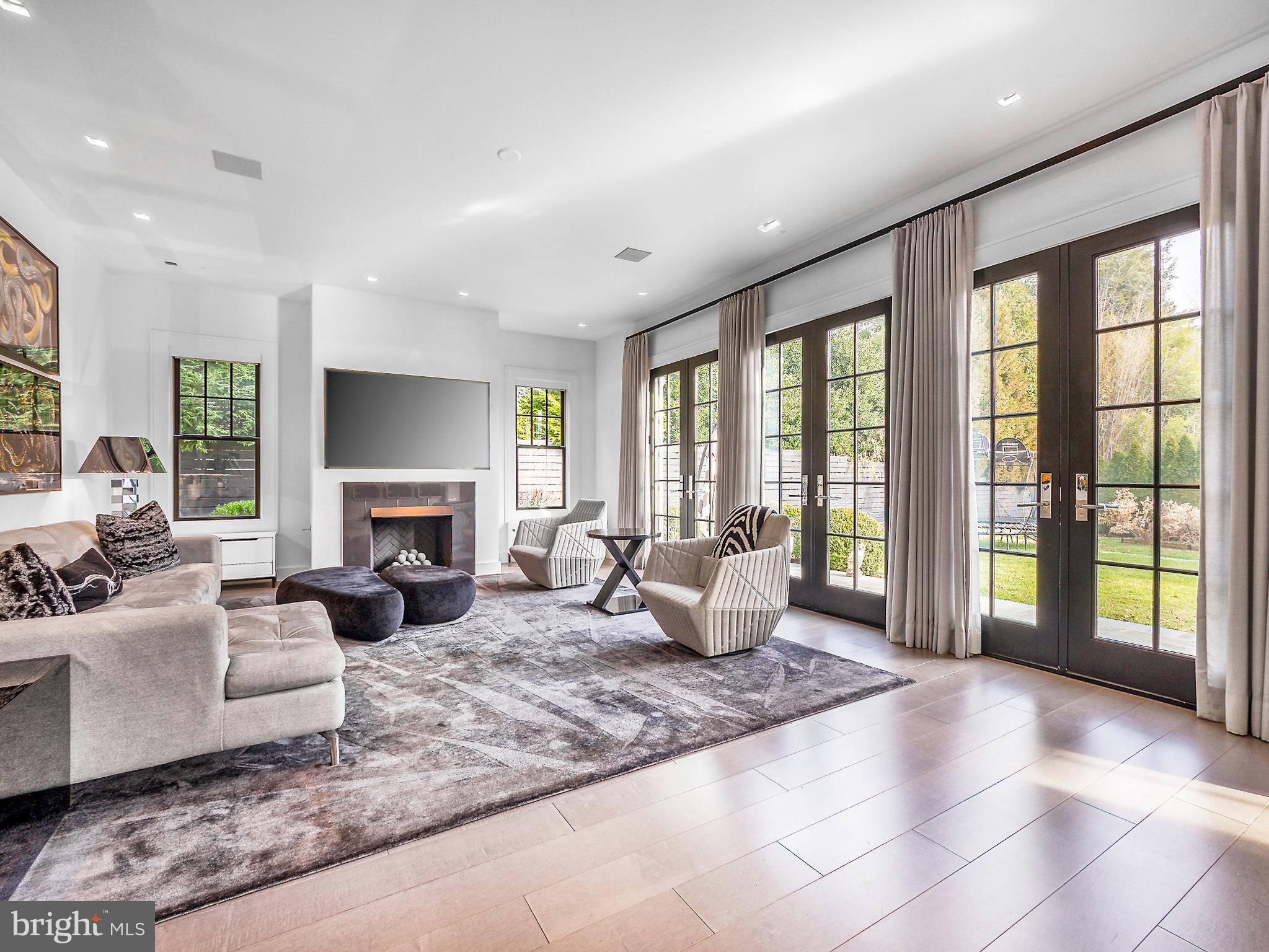a living room with furniture large windows and a fireplace
